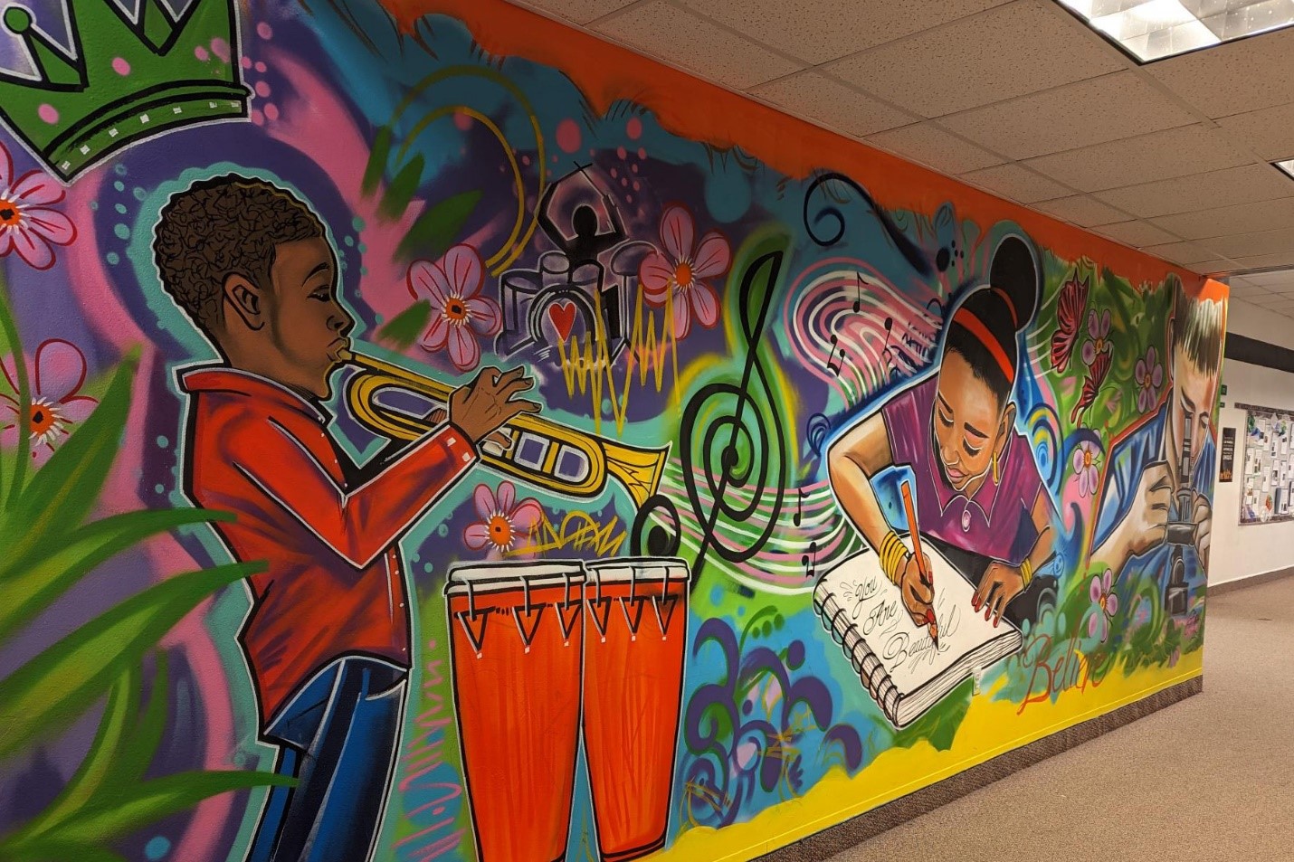 A mural at Cleveland Heights-University Heights City School District. A Young boy plays an instrument and young girl writes in a journal.